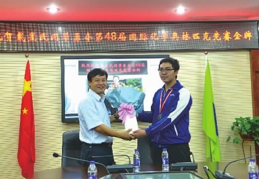 8月3日，湖南师大附中校长谢永红（左）为在第48届国际中学生化学奥林匹克竞赛中获得金牌的戴昱民同学送上祝福和鲜花。
